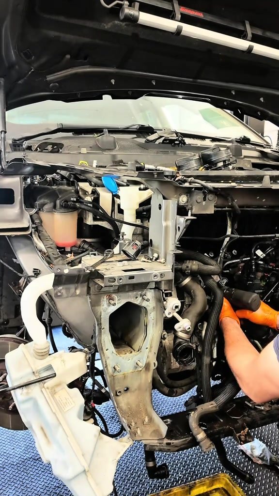 Front end of a 2017 Land Rover Discovery Sport stripped for access to the thermostat housing and turbo
