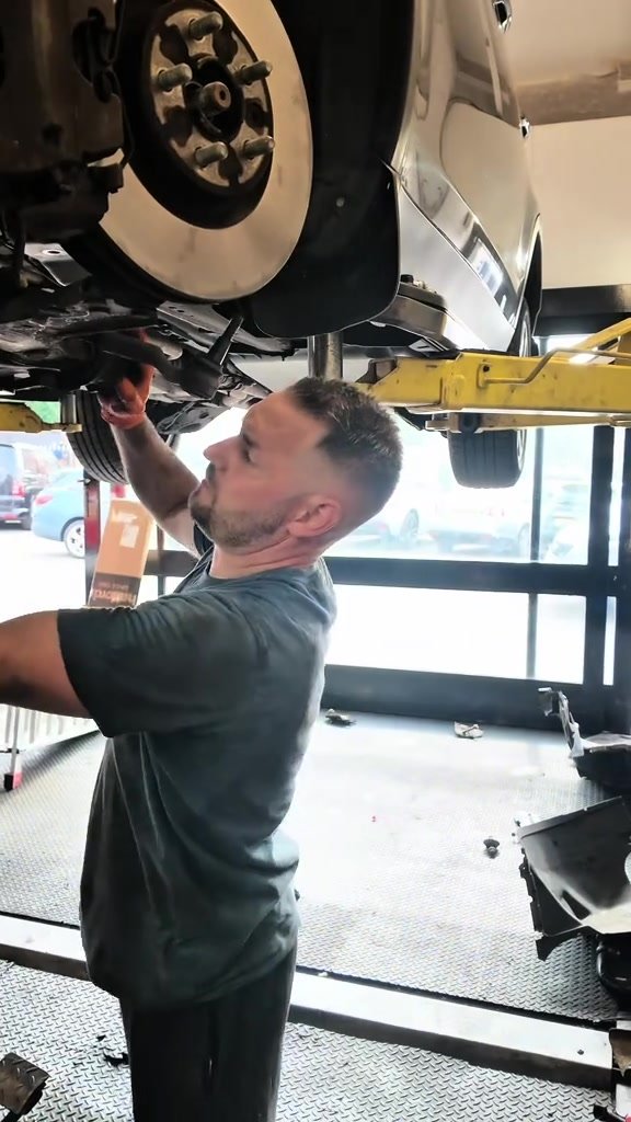 Technician working underneath the Discovery Sport on the ramp at Star Garage Mansfield