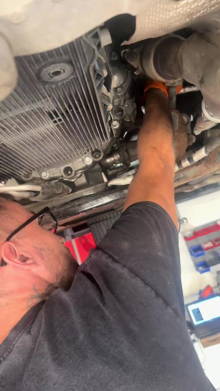 Technician working underneath a blue Jaguar during a differential seal repair at Star Garage Mansfield