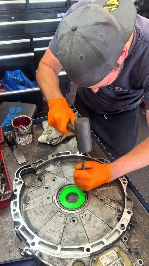 Fitting a new rear main oil seal into the timing chain casing of a Jaguar on the bench