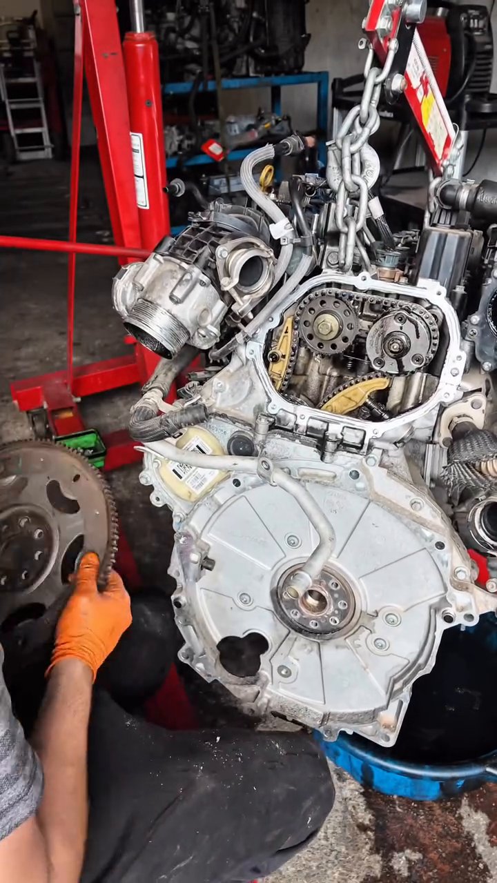 Second-hand replacement engine for a Range Rover Evoque being prepared on an engine crane